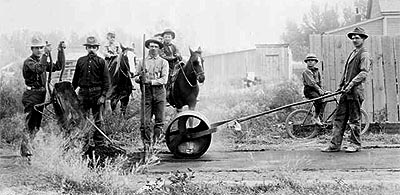 Laying sidewalk in Rifle, Garfield County, Colorado circa 1905.  Men work with rakes, a wheelbarrow, tar, and a roller. Boys on horses or a bicycle look on.  Date [between 1905 and 1915?] Call Number X-13183.  Formerly F28425. 

Hyperlink to Denver Public Library.