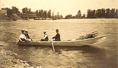 The rowboat of Frank L. Chambers at the Ferry Street Bridge.  Pictured: P. E. Snodgrass, Amy Snodgrass, Mary Chambers Brockelbank, F. L. Chambers and Fred Chambers.  No date.  Print No: 70.