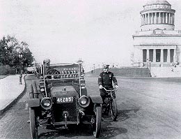 A bicycle officer stopping a car by Grant's Tomb, circa 1910.